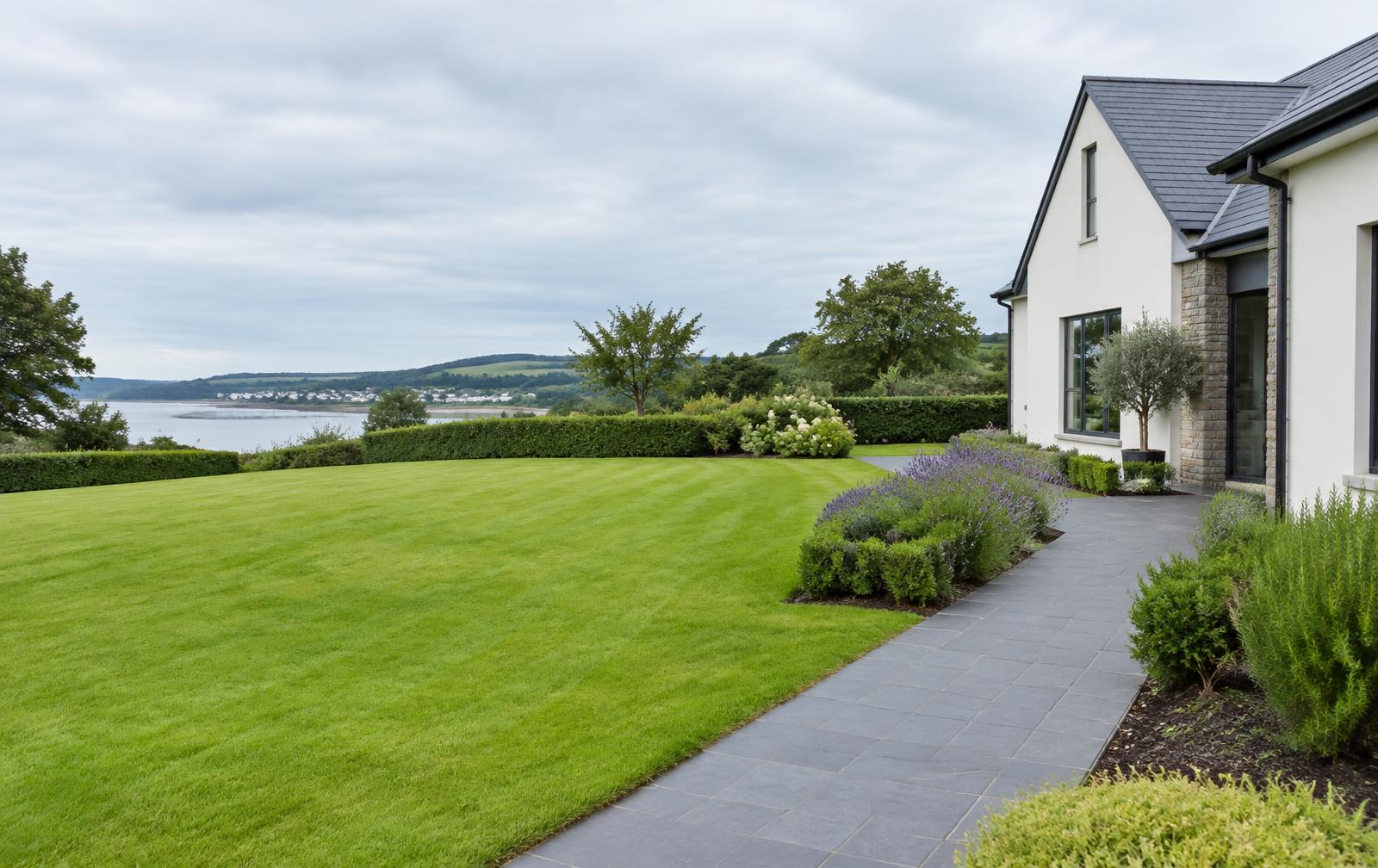 Well-maintained lawn, hedges and planted beds beside a Waterford property